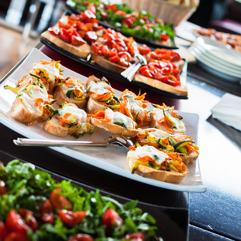 Italian buffet table showing bruschetta, salads, and other Italian dishes