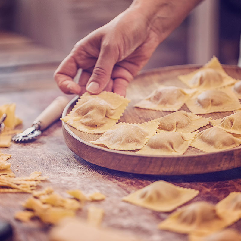 Ravioli being prepared and displayed on a wooden plate. istockphoto by GMVozd